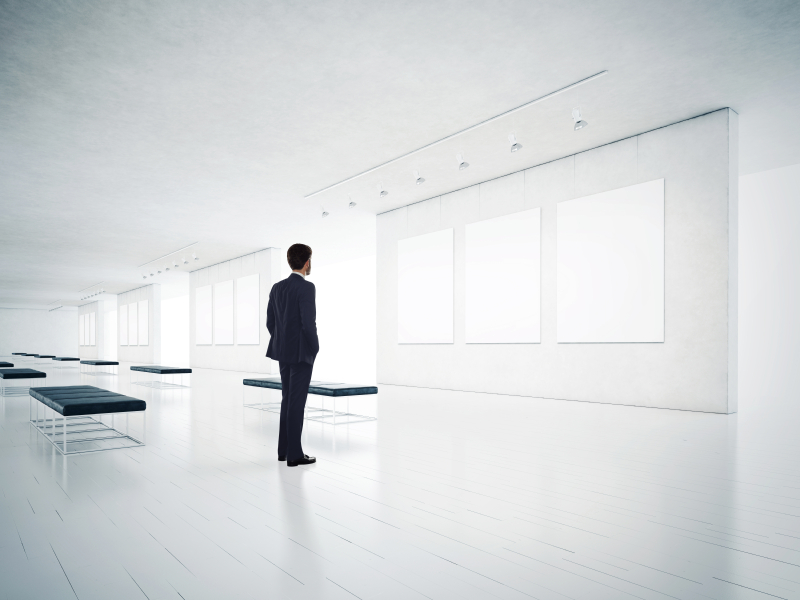 Gallery room and man looking at empty frames iStock_000044195132_Small