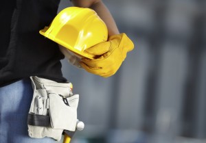 builder with yellow helmet and working gloves on building site