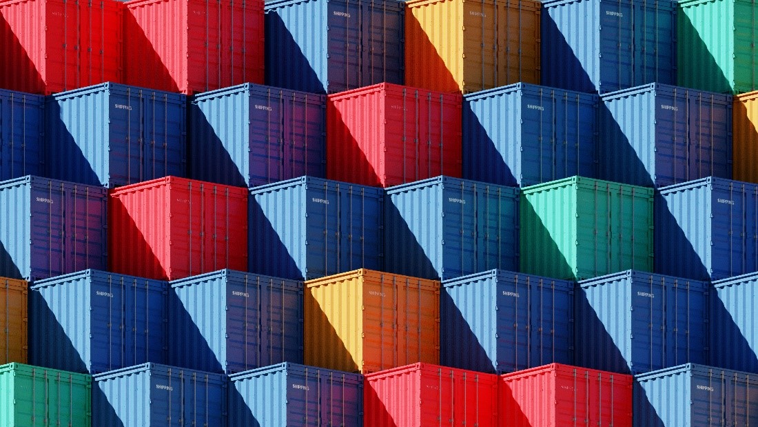 A series of multi-coloured shipping containers lined up in a pattern, two blue, red, two blue