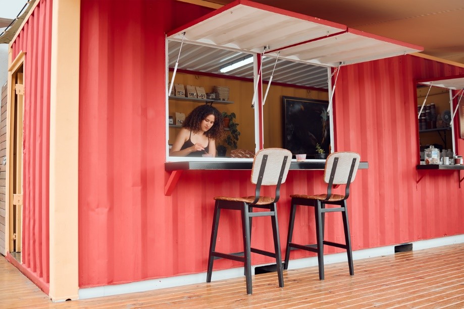 Woman working in a steel container that's been renovated into a coffee shop